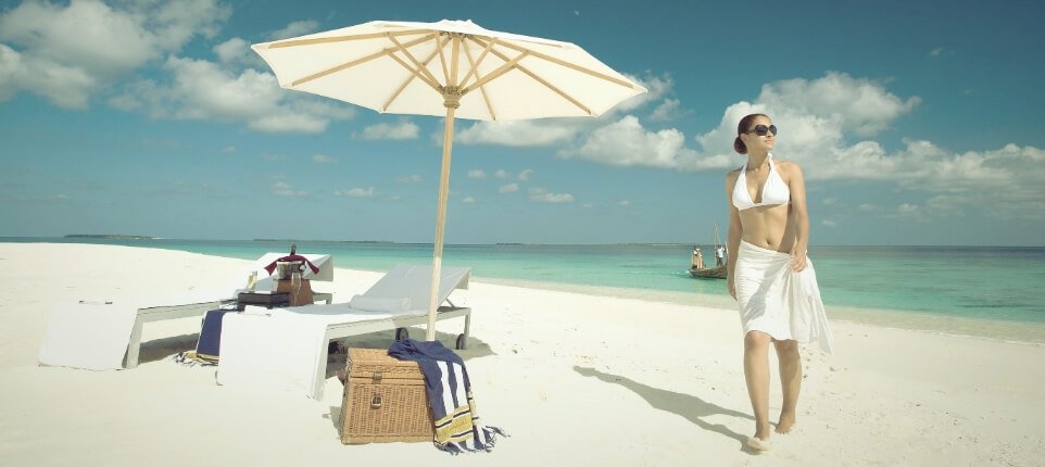 امرأةتسيربجانبمظلةعلىالشاطئ