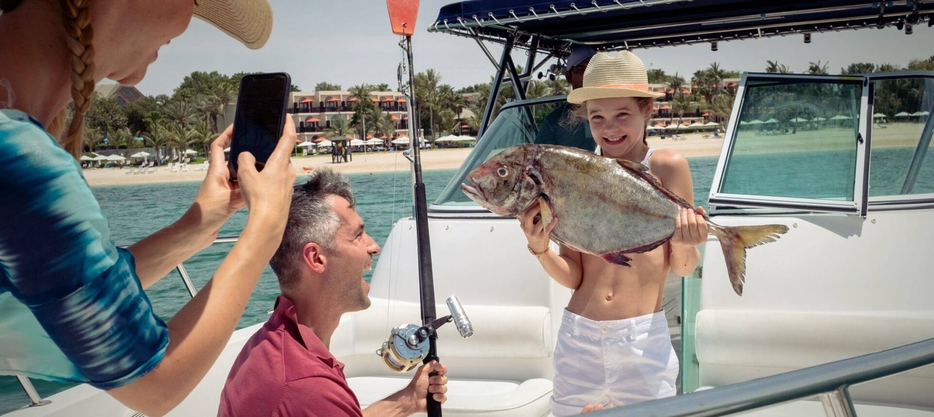 فتاةتتباهىبسمكةقامتبصيدها